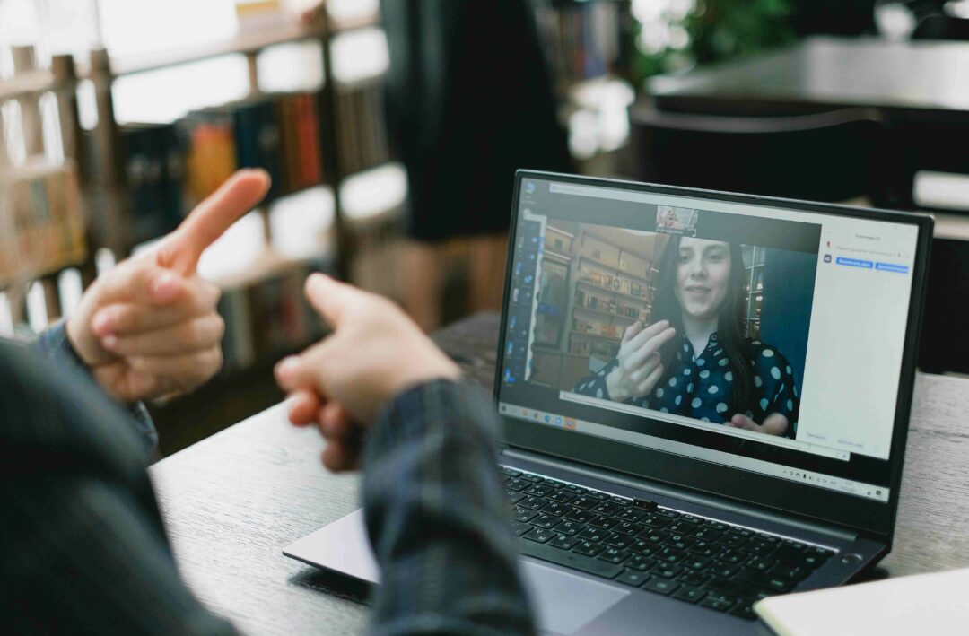 two people communicating in sign language on a video call